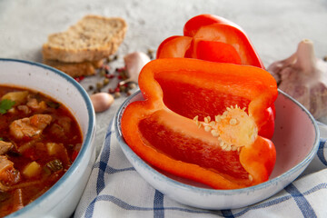 Ripe paprika and Hungarian goulash soup on the table. Traditional cuisine, national dish.