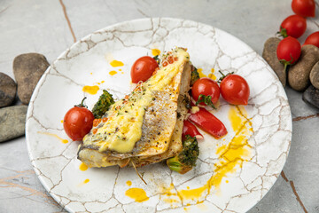 baked sea bream fish with tomatoes, peppers, sauce and broccoli
