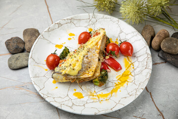 baked sea bream fish with tomatoes, peppers, sauce and broccoli
