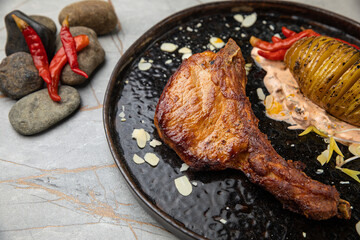 The meat is grilled, with bone, fried potatoes, sauce. 