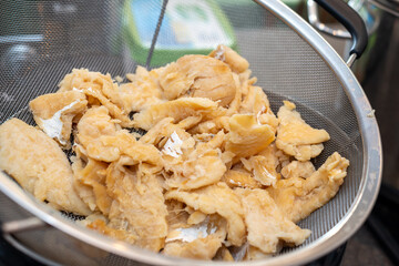 A metal dish containing cooked and cleaned salt cod fish. The dried and salted cod is white and flaky to preserve. The prepared food is for making cakes and brews with potatoes. The fillet is deboned.