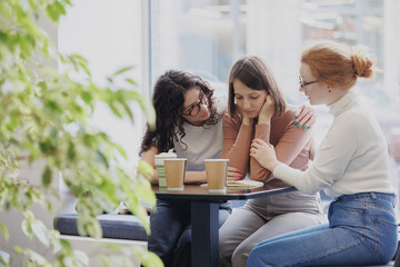 friendship and support in a difficult situation, three female friends discuss the problem and support each other, depression and sadness in a woman, group psychotherapy and support from friends and