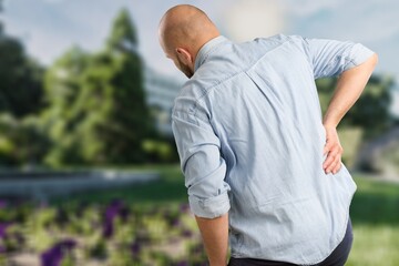 Man's is caught at the waist and her back is painful at the back in the park.