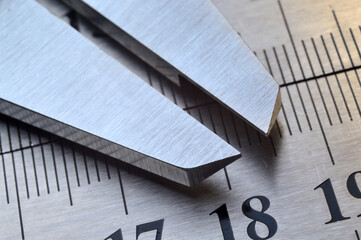 Accurate measuring tool caliper and metal ruler lie on top of each other. close-up.
