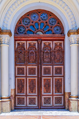 A carved wooden side door of a cathedral in Cuenca, Ecuador (Cataral Metropolitana de la Inmaculada Concepción）