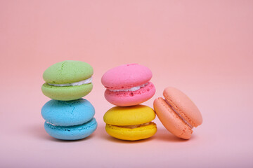 Colorful and bright macarons cookies pink background.