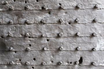 Texture of the iron space, close-up. Background of metal surface from sheets with rivets. A metal relief backing for branding, calendar, postcard, screensaver, wallpaper, poster, banner, cover