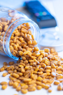 Roasted salted corn snack in jar on white table.