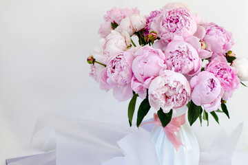 Bouquet of pink peonies in a white vase.