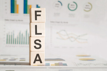 Wooden block with words FLSA - acronym FLSA - Fair Labor Standards Act.