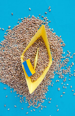grain wheat and spikelets on a blue background. Ukrainian grain and problems of blockade of ports.