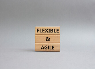 Flexible and agile symbol. Concept word Flexible and agile on wooden blocks. Beautiful grey background. Business and Flexible and agile concept. Copy space