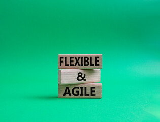 Flexible and agile symbol. Concept word Flexible and agile on wooden blocks. Beautiful green background. Business and Flexible and agile concept. Copy space