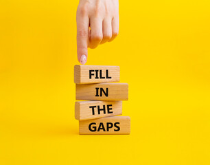Fill in the gaps symbol. Concept words fill in the gaps on wooden blocks. Beautiful blue background. Business and fill in the gaps concept. Copy space.