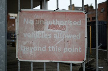 Obraz premium Old Faded Metal Sign on Gate of Industrial Yard in Close Up