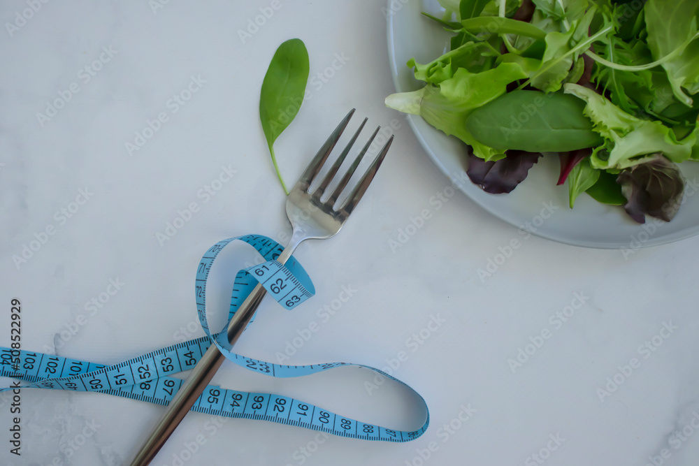 Wall mural lettuce leaves measuring tape on a plate