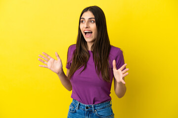 Young caucasian woman isolated on yellow background with surprise facial expression