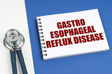 On a blue-white surface lies a stethoscope and a notepad with the inscription - Gastro Esophageal...
