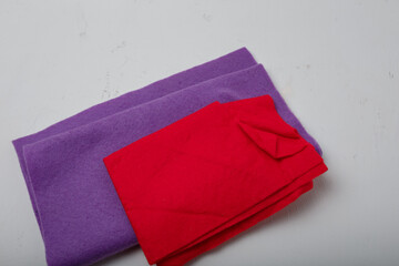 two pieces of purple and red felt for needlework and sewing on white background, fabric and handiwork