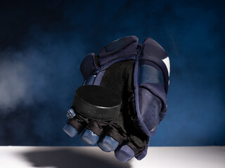 Closeup of ice hockey equipment against a smoky background. Hockey puck, ice hockey stick, ice...