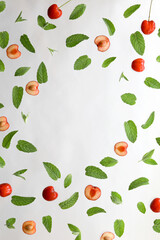 Summer background, frame with fresh cherry fruits and mint on white background. Flat lay. Summer fruits concept.