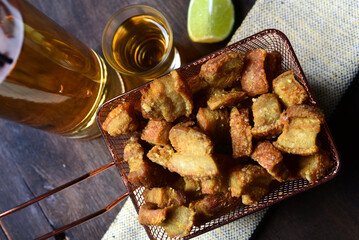 delicious fried and roasted pork skin, typical brazilian food, pancetta served in a metal basket