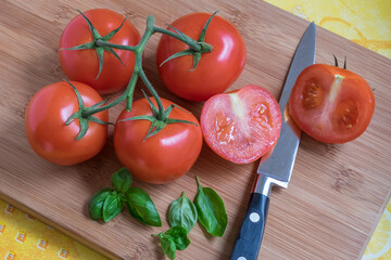 Tomates en rama sobre una tabla de cocina