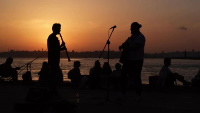 Two blurry street musicians are performing in the sunset in Istanbul, Kadikoy, Turkey in 2022 summer.