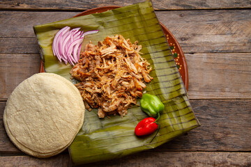 Cochinita pibil in banana leaves with habanero peppers. Mexican food