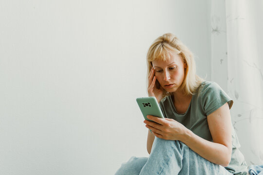 Close-up image of pretty woman sitting at cozy home interior and using modern smartphone device, female hands typing text message via cellphone, social networking concept
