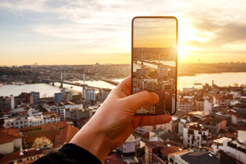 Istanbul at sunset, Turkey. Taking a photo cityscape by cell phone.