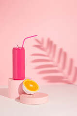 Pink colored can with cut in half orange fruit on product podium and shadow. Summer drink minimal...