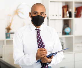 Viral threat, seasonal viral diseases. Man works in the office in a medical mask, protecting office workers from viruses