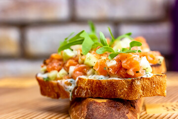 dry aged smoked salmon on the slices of bread and cream cheese sandwiches with cherry tomatoes and rocket salad