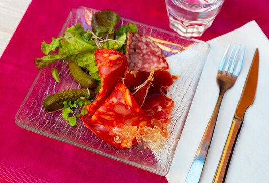 Delicious smoked assorted meat of dried sausage and sliced carbonade, served with pickled gherkins and lettuce leaves