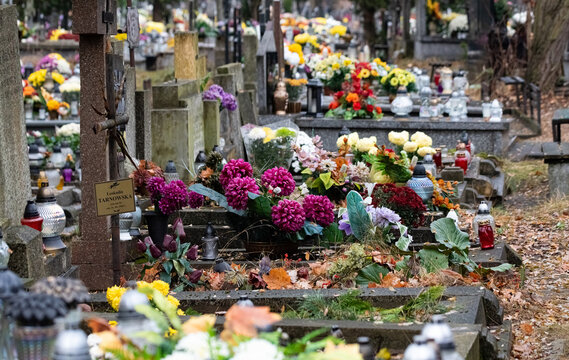All Saints' Day, burning candles and flowers on the graves. Catholic cemetery during All Saints' Day. Candles on graves symbolize the memory of the dead on November 1.
