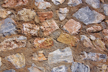Texture of an old stone wall from different stones of different shades.