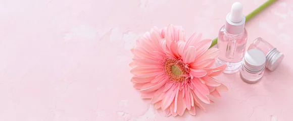 Foto op Plexiglas Bottles of essential oil and gerbera flower on pink background with space for text © Pixel-Shot