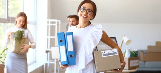 Beautiful businesswoman with folders and box in office on moving day
