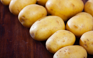 Raw potato tubers on a wooden table. High quality photo