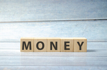concept of money word on wooden cubes on wooden background