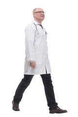 mature doctor in a white coat striding forward