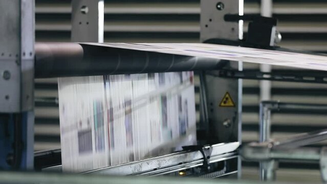The printing process of a weekly magazine with facilities of a copier shop. Close-up shot of newspaper production on a conveyor belt. High quality FullHD footage