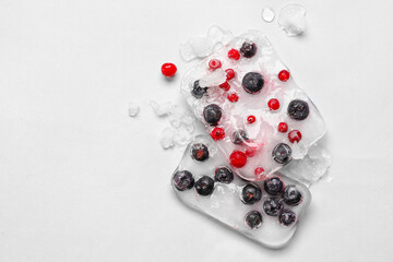 Fresh berries frozen in ice on light background