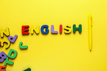 Word ENGLISH with pen and letters on yellow background