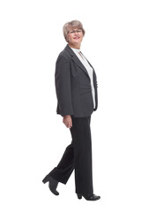 Side view of happy senior businesswoman wearing glasses and walking