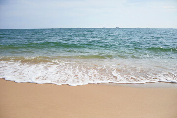 Fototapeta na wymiar Sand and beach with frothy wave