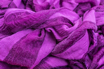 Close-up photo of a fragment of folds of fabric of purple color. Best for background