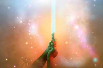 a fantastic laser sword lightsaber in the hands of a man - 508542540