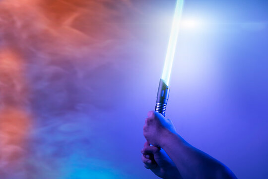 a fantastic laser sword lightsaber in the hands of a man